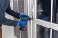 Handsome man using a screwdriver to install a window handle and looking at the camera. Making a house cozy and warm Royalty Free Stock Photo