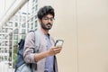 Handsome man using smartphone in a city. Smiling student men texting on his mobile phone. Young businessman with mobile phone Royalty Free Stock Photo