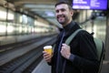Handsome man waiting for a train with coffee cup Royalty Free Stock Photo