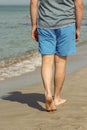 Handsome man walking alone on the beach with bare feet. Rest by the beach.