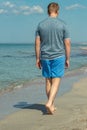 Handsome man walking alone on the beach with bare feet. Rest by the beach.