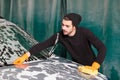 A handsome man is washing a car