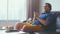 Handsome man watching a football match in his living room.