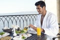 Handsome man wearing bathrobe & having breakfast outdoor Royalty Free Stock Photo