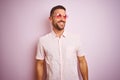 Handsome man wearing elegant summer shirt and sunglasses over pink isolated background looking away to side with smile on face, Royalty Free Stock Photo