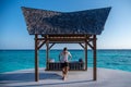 Handsome man wearing fashionable shirt walking near standing meat swing at the tropical island luxury resort Royalty Free Stock Photo