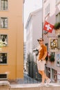 Handsome man wearing sunglasses and shirt walking in old town street Royalty Free Stock Photo