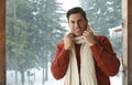 Handsome man wearing warm sweater and scarf on snowy day. Winter season