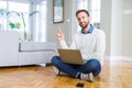 Handsome man wearing working using computer laptop with a big smile on face, pointing with hand and finger to the side looking at Royalty Free Stock Photo