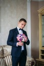 Handsome man in wedding suit hold a bouquet of flowers Royalty Free Stock Photo