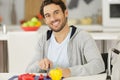 Handsome man in wheelchair chopping vegetables Royalty Free Stock Photo