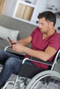 Handsome man in wheelchair texting on phone Royalty Free Stock Photo
