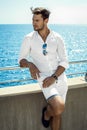 Handsome man in whit clothes resting by the sea Royalty Free Stock Photo