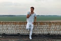 Handsome man in white clothes standing near the brick wall Royalty Free Stock Photo