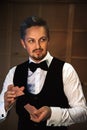 Handsome man in a white shirt with a bow tie shuffles the cards Royalty Free Stock Photo