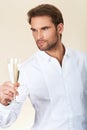 Handsome man in white shirt celebrating with a glass of champagne