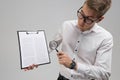 Young man in glasses with insurance and magnifier in hand on white background