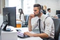 Handsome man working in call center. Customer support operator with headset working in office with his colleagues. Royalty Free Stock Photo