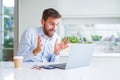 Handsome man working using computer laptop and drinking a cup of coffee very happy and excited, winner expression celebrating Royalty Free Stock Photo