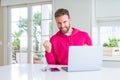 Handsome man working using computer laptop very happy and excited doing winner gesture with arms raised, smiling and screaming for Royalty Free Stock Photo