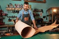 Craftman in apron working with leather at workshop Royalty Free Stock Photo