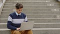 Caucasian Man Working with Laptop Outside. Businessman Using Laptop, Sitting on Stairs.