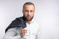 Handsome manful businessman holding his jacket over shoulder on white background