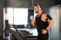 Handsome Masculine Man Wearing Wireless Headphones Running On Treadmill At Gym Royalty Free Stock Photo