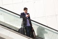 Handsome mature business man on escalator using mobile phone Royalty Free Stock Photo