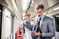 Mature businessman with smartphone in a metro train. Royalty Free Stock Photo