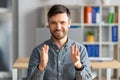 Handsome mature businessman making video call, having virtual online meeting, talking and gesturing to camera in office Royalty Free Stock Photo