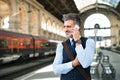 Mature businessman with smartphone on a train station. Royalty Free Stock Photo