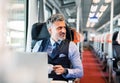 Mature businessman with laptop travelling by train. Royalty Free Stock Photo