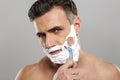 Handsome mature concentrated man naked shaving.