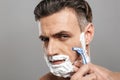 Handsome mature concentrated man naked shaving.