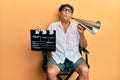 Handsome mature director man holding video film clapboard and louder looking at the camera blowing a kiss being lovely and sexy