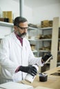 Handsome mature engineer in the laboratory examines ceramic tiles Royalty Free Stock Photo