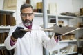 Handsome mature engineer in the laboratory examines ceramic tiles Royalty Free Stock Photo