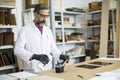 Handsome mature engineer in the laboratory examines ceramic tiles Royalty Free Stock Photo