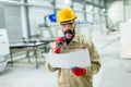 Handsome mature engineer looking at plan in the factory Royalty Free Stock Photo