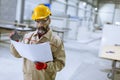 Handsome mature engineer looking at plan in the factory Royalty Free Stock Photo