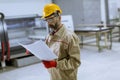 Handsome mature engineer looking at plan in the factory Royalty Free Stock Photo