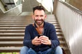 Handsome mature guy with cellphone on steps Royalty Free Stock Photo