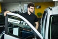 Handsome mature male customer sitting in a new car at the car dealership Royalty Free Stock Photo