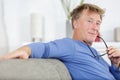 handsome mature man with eyeglasses relaxing in sofa at home Royalty Free Stock Photo