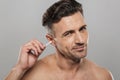 Handsome mature man holding cotton bud take care of his ears cleaning it. Royalty Free Stock Photo