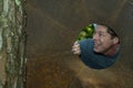 Handsome mature man in the iron plate hole, looking away, grins, happy, contented. Royalty Free Stock Photo