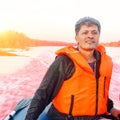 A handsome mature man in a life jacket walks on a boat along Royalty Free Stock Photo