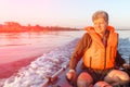 A handsome mature man in a life jacket walks Royalty Free Stock Photo
