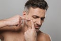 Handsome mature man naked take care of his skin squeezes out a pimple. Royalty Free Stock Photo
